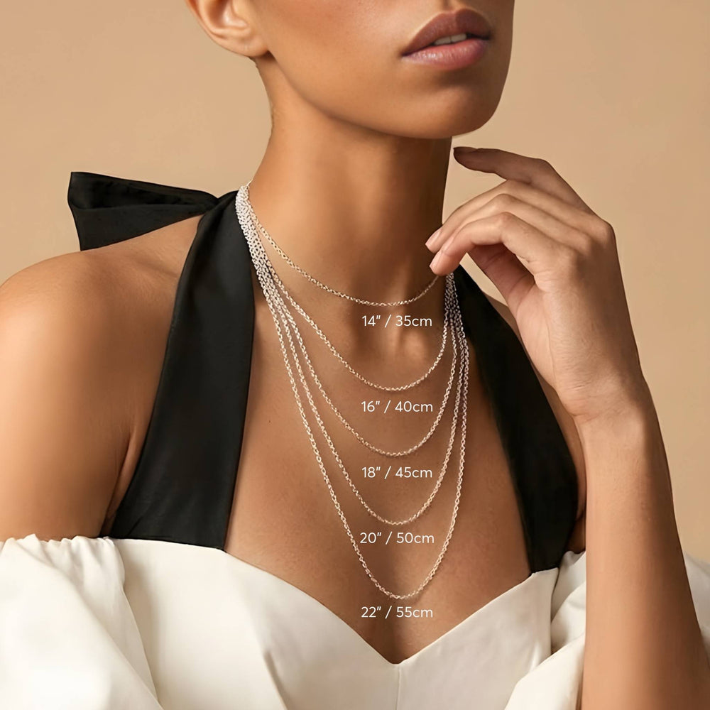 Woman wearing a necklace with labeled chain lengths on a beige background