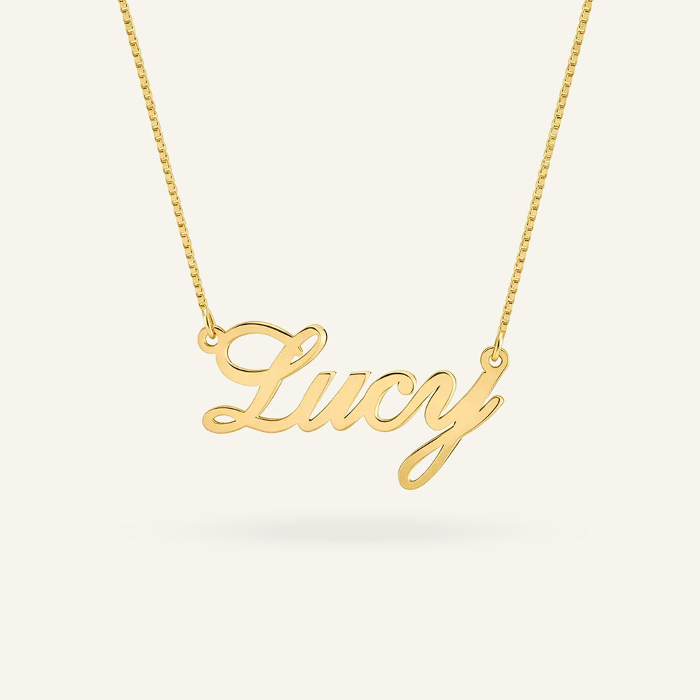 Personalized 'Lucy' name necklace in 24k gold plating on a delicate box chain, showcasing elegant cursive script.