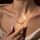 Close-up of a woman wearing a gold plated sterling silver custom name necklace with "Presley" across her collarbone.