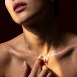 Woman wearing a gold-plated sterling silver personalized "Emily" name necklace, with sunlight accentuating the jewelry.